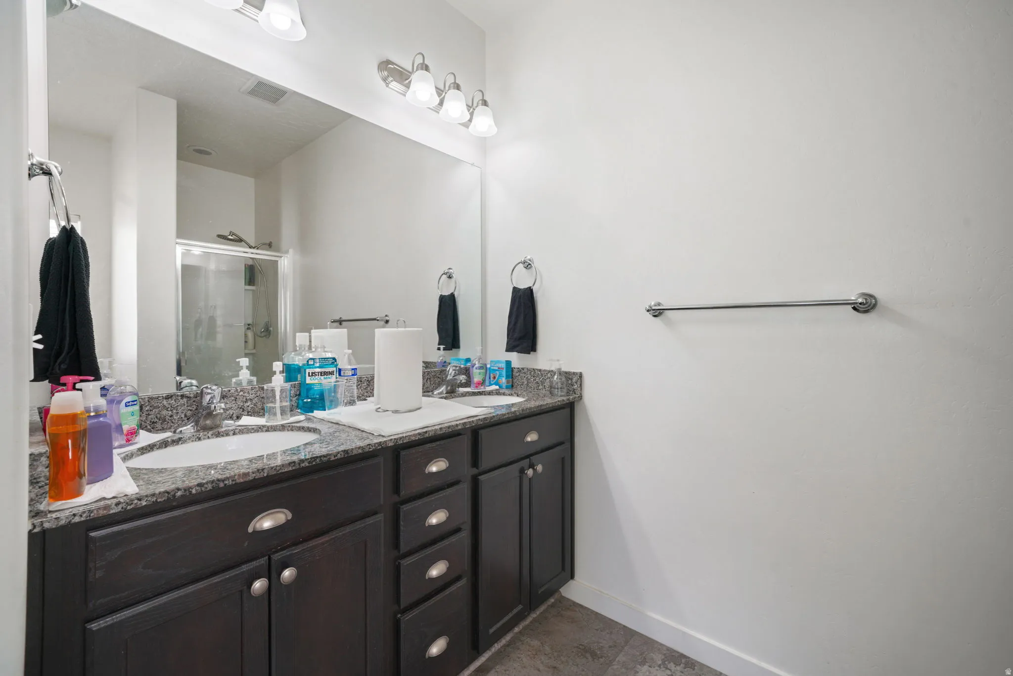 Bathroom featuring double vanity and a shower stall