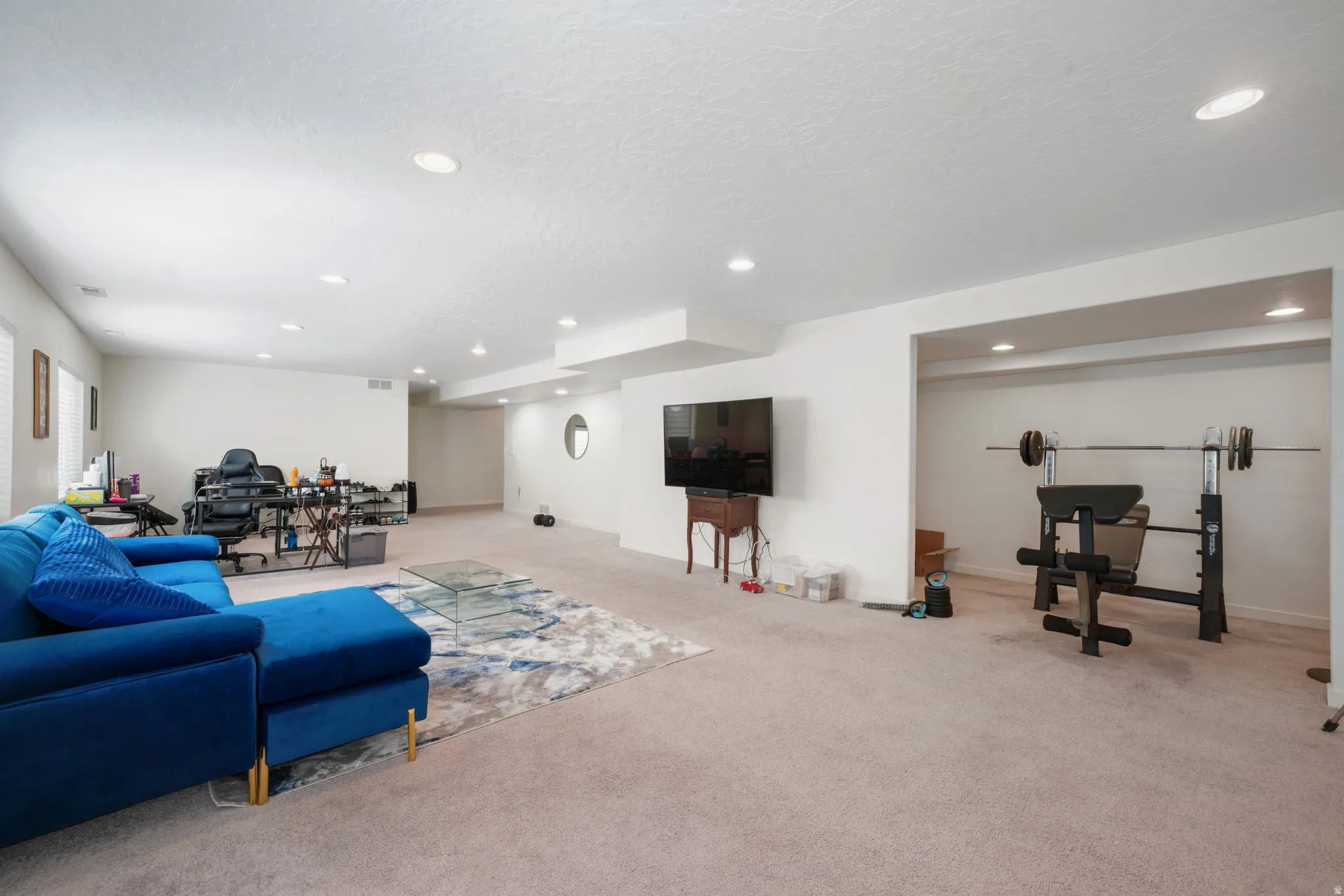 Living room featuring light colored carpet, recessed lighting, and a textured ceiling