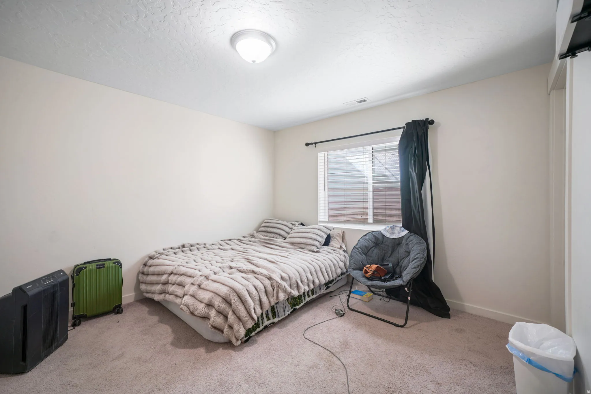 Carpeted bedroom with baseboards and a textured ceiling