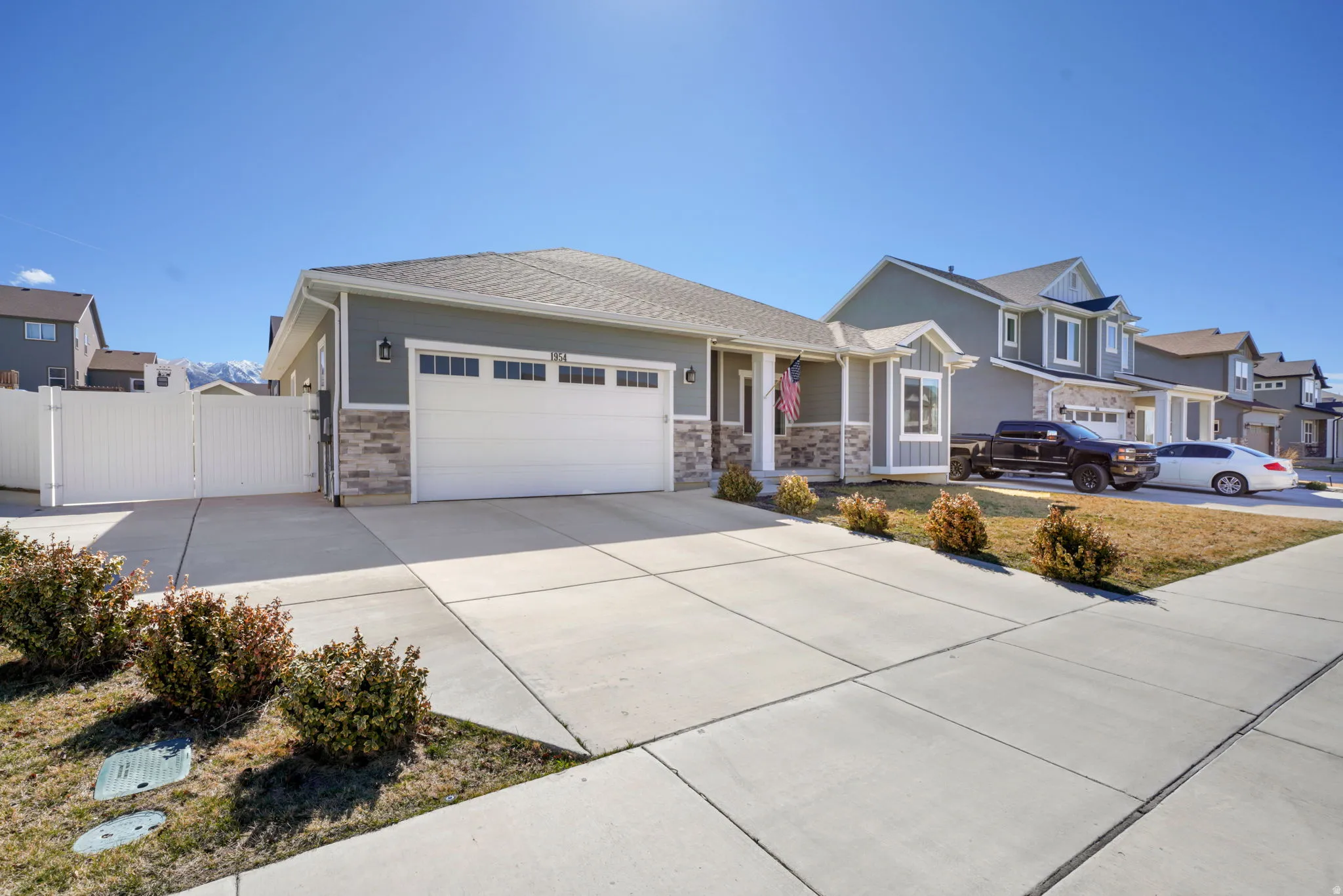 View of front of home with a gate, a garage, driveway, and a residential view