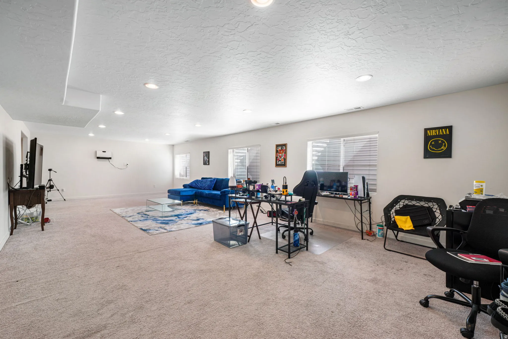 Living area with a textured ceiling, light carpet, healthy amount of natural light, recessed lighting, and a desk