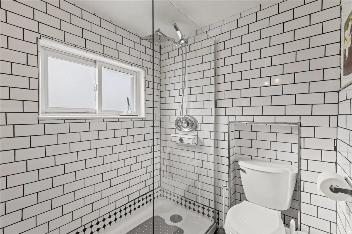 Bathroom with a stall shower and tile walls