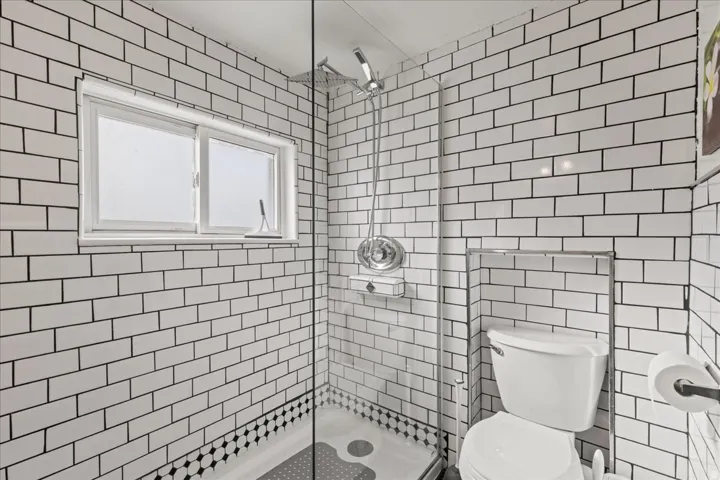 Bathroom with a stall shower and tile walls