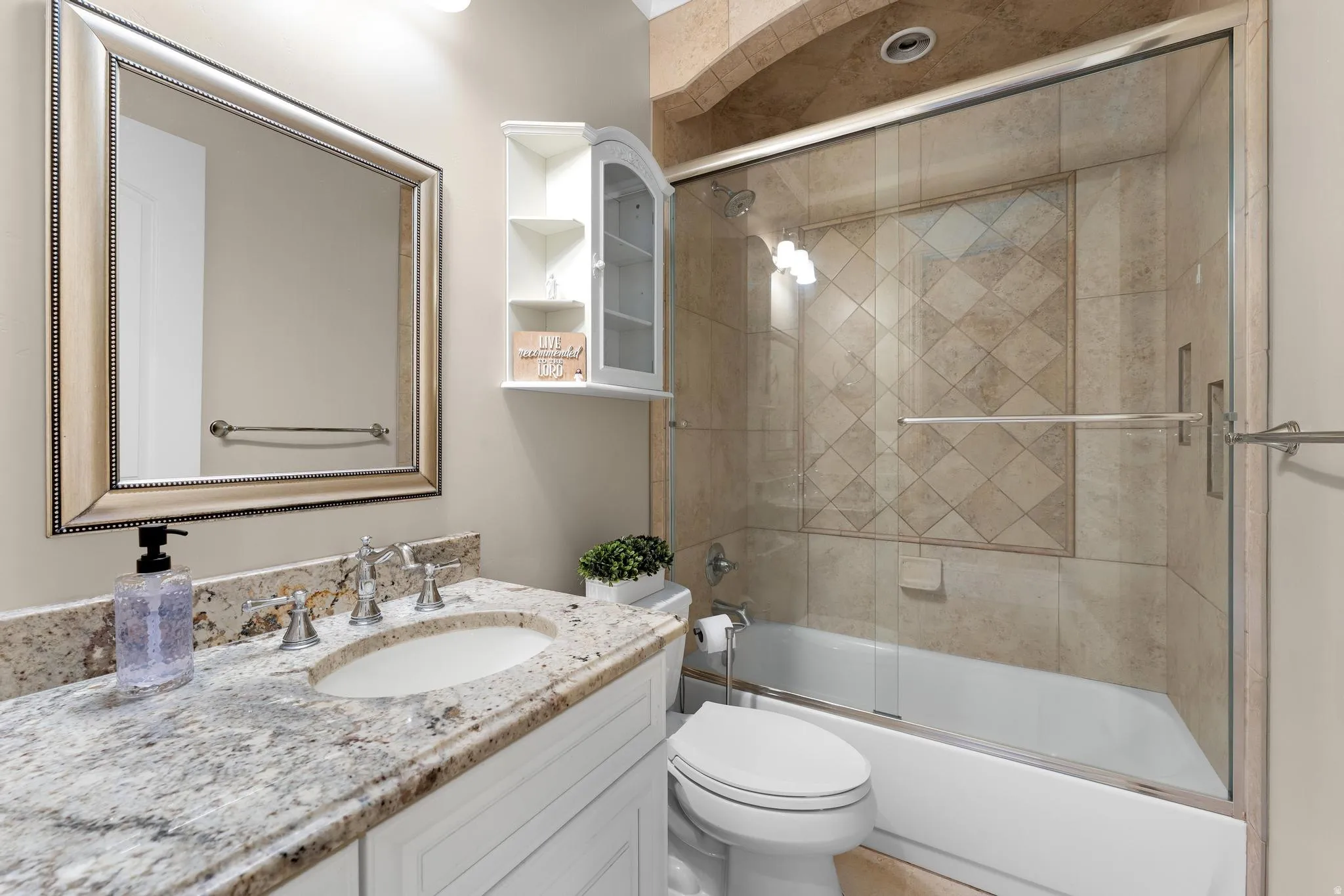 Bathroom featuring vanity and combined bath / shower with glass door