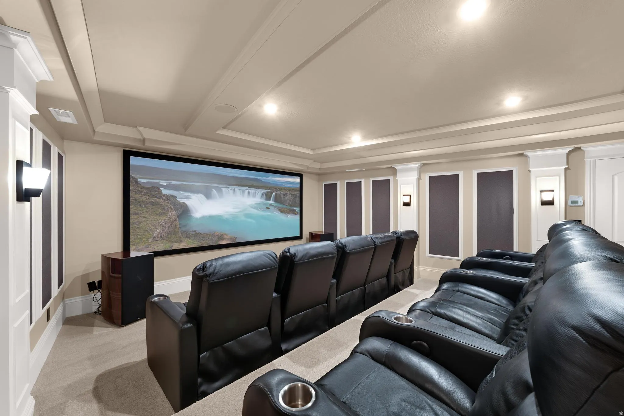 Cinema room with light carpet, a tray ceiling, and recessed lighting
