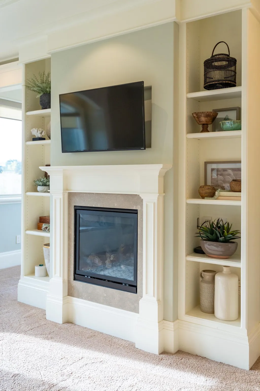 Detailed view of built in shelves, carpet flooring, and a glass covered fireplace
