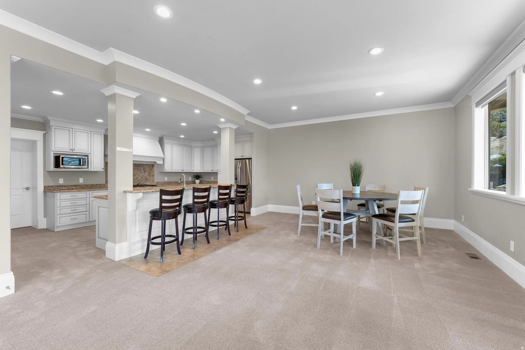 Dining room featuring light colored carpet, ornamental molding, and recessed lighting