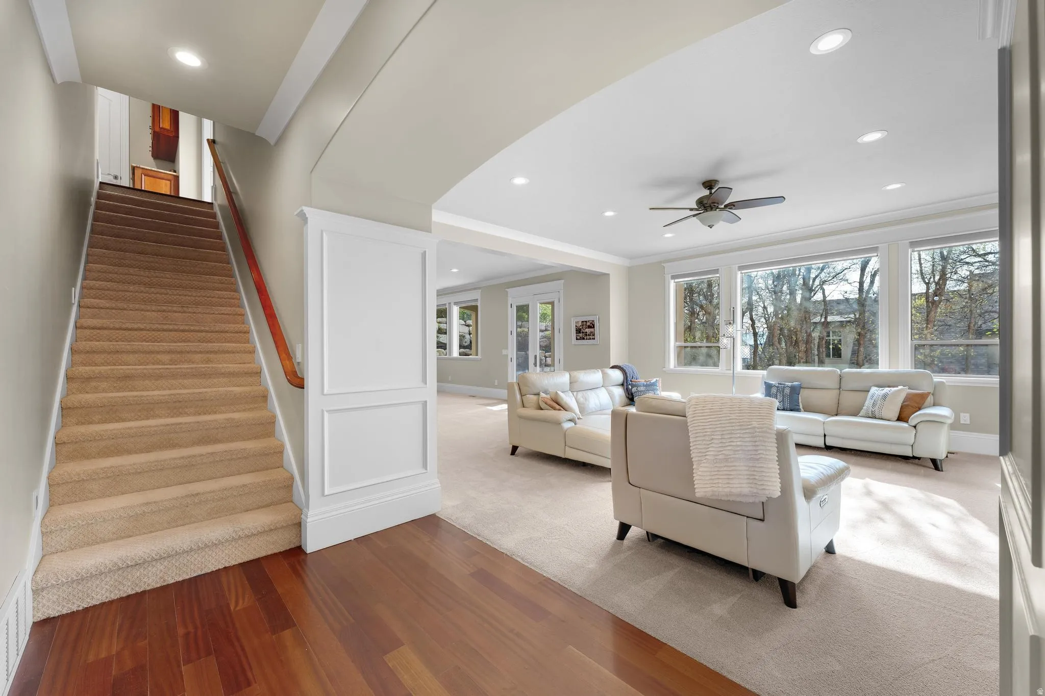 Carpeted living room with recessed lighting, a ceiling fan, ornamental molding, and wood finished floors