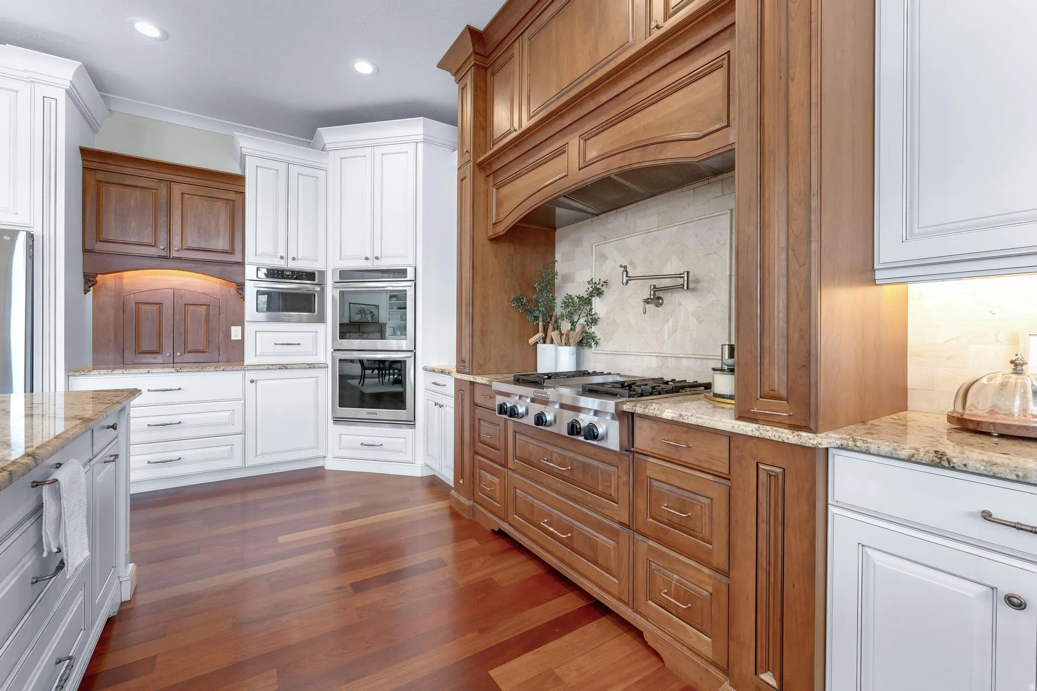 Kitchen featuring light stone countertops, white cabinetry, dark wood-type flooring, stainless steel appliances, and recessed lighting