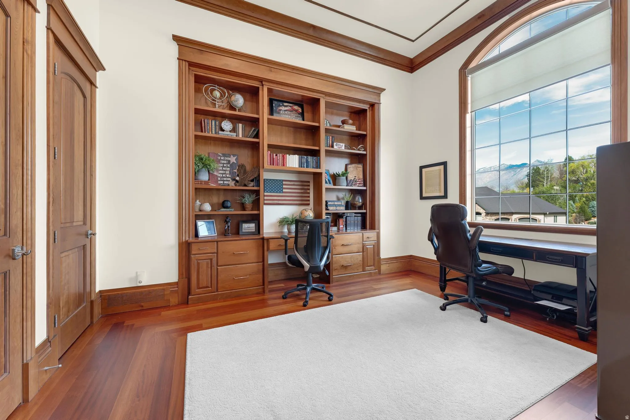 Home office featuring dark wood-style flooring and crown molding