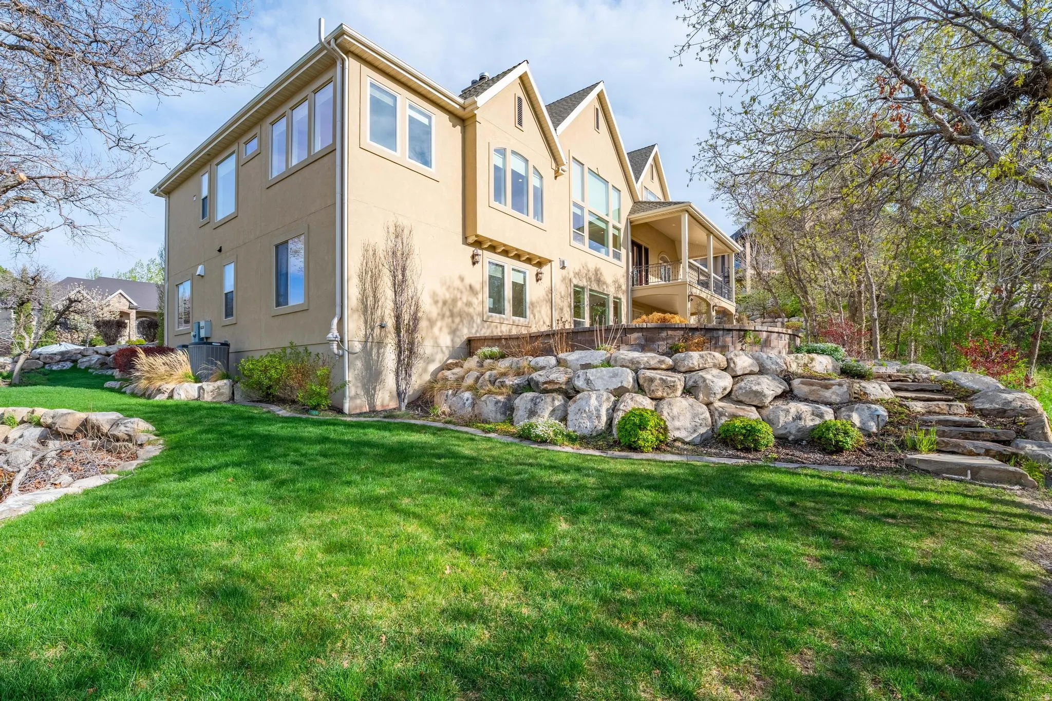 Rear view of property with a lawn and stucco siding