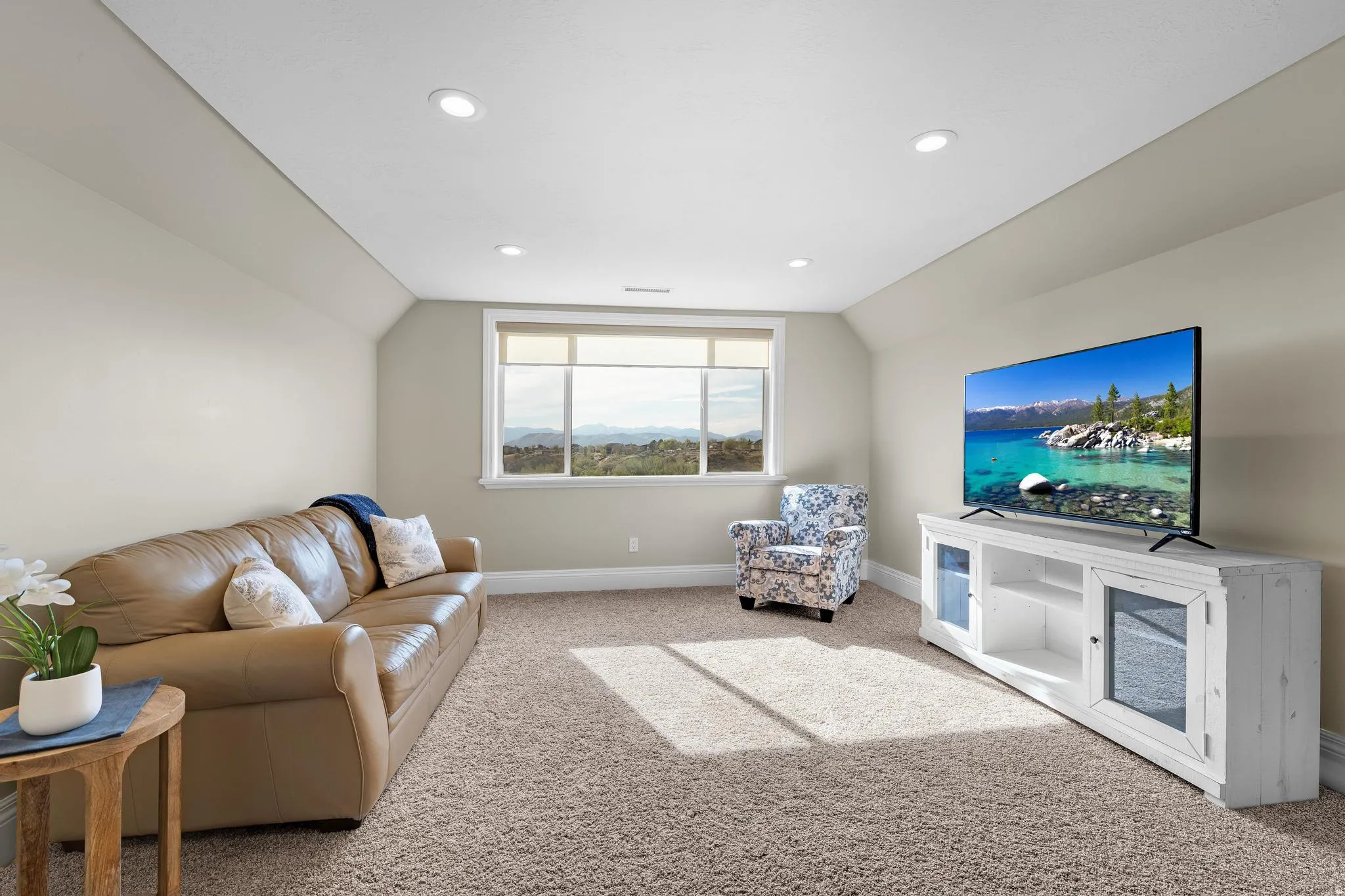 Living area with vaulted ceiling, light carpet, and recessed lighting