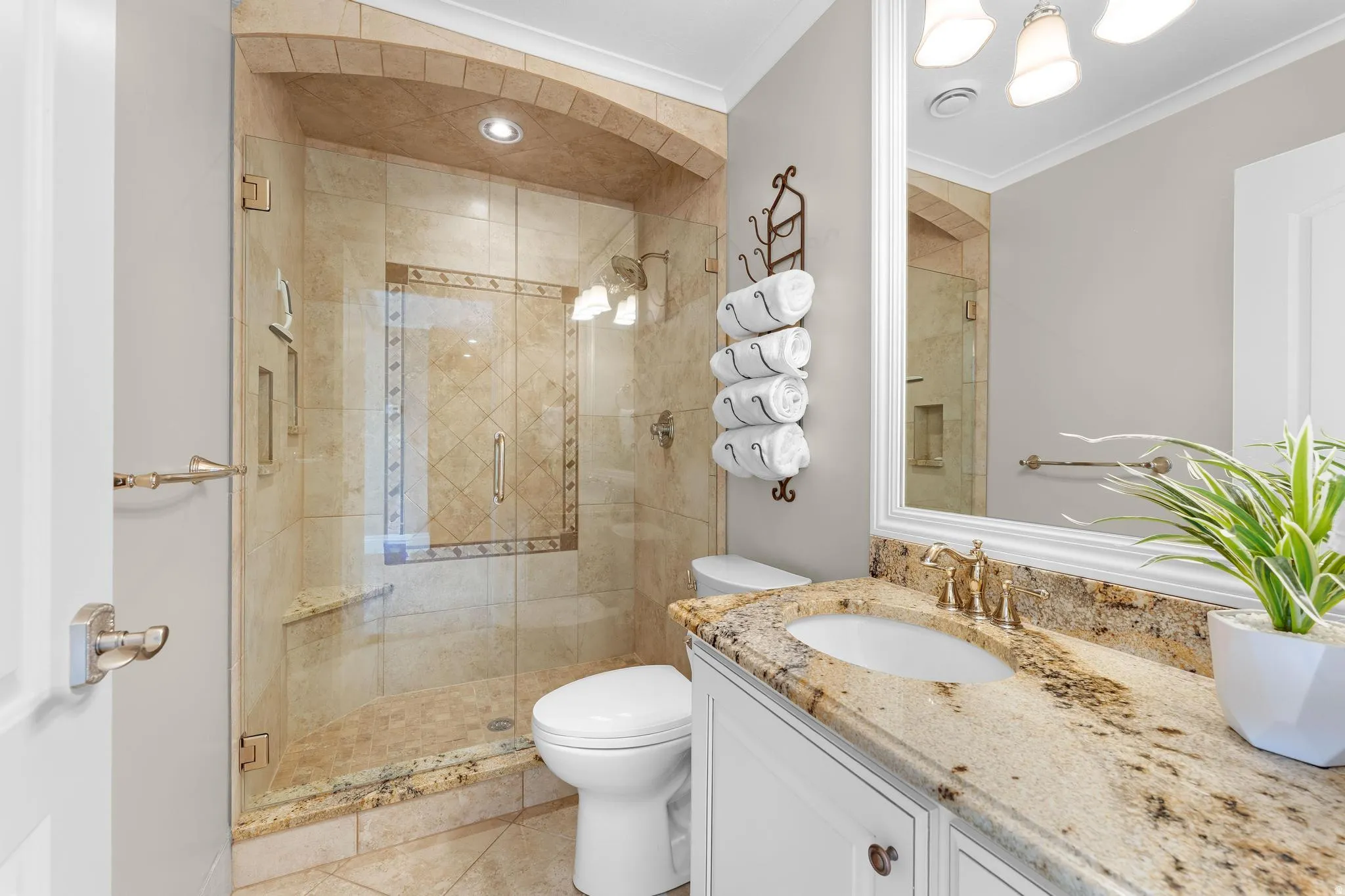 Bathroom with vanity, a stall shower, and crown molding