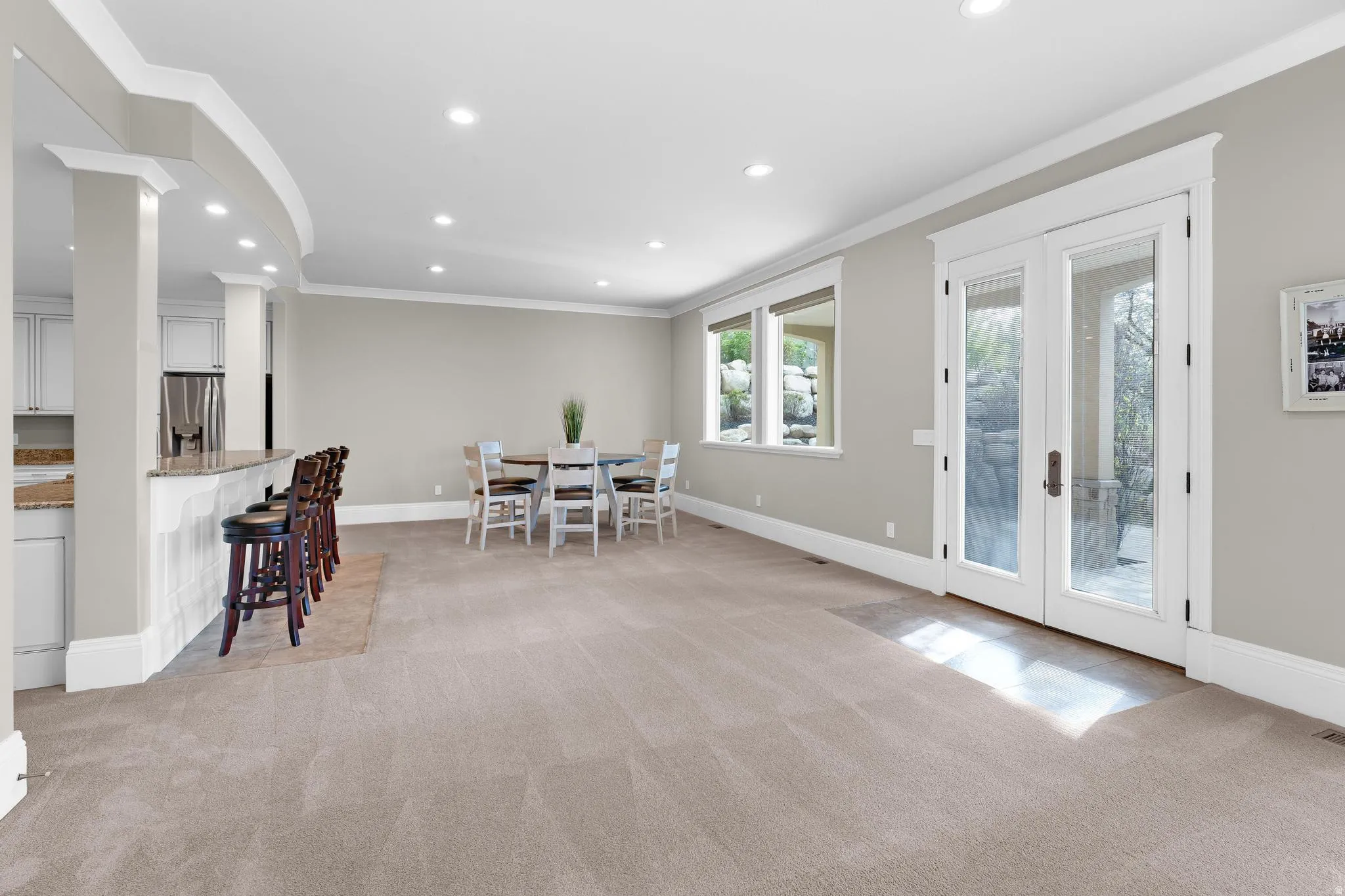 Dining space featuring light carpet, crown molding, recessed lighting, and french doors