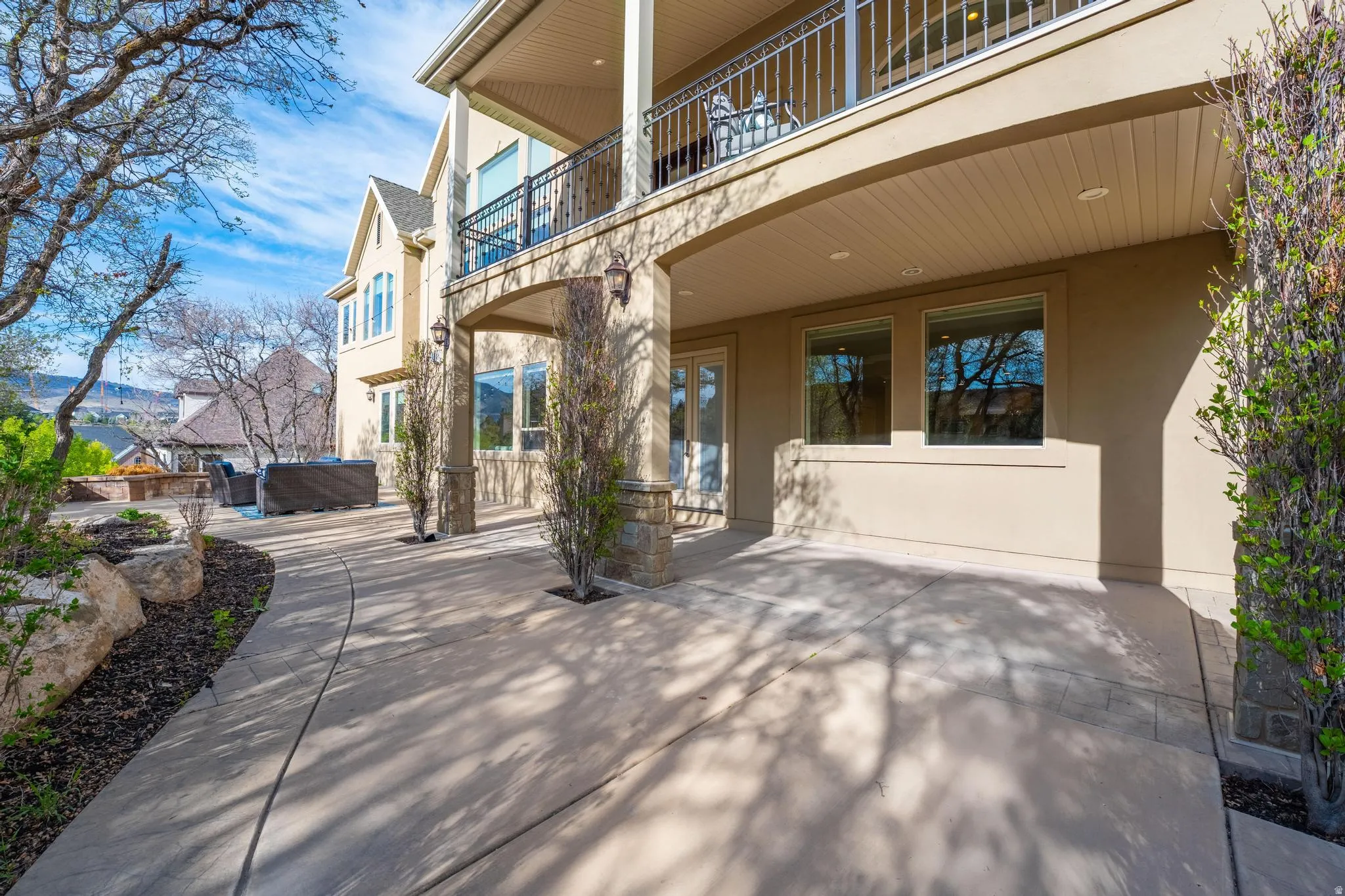 Property entrance with stucco siding, a patio area, and a jacuzzi