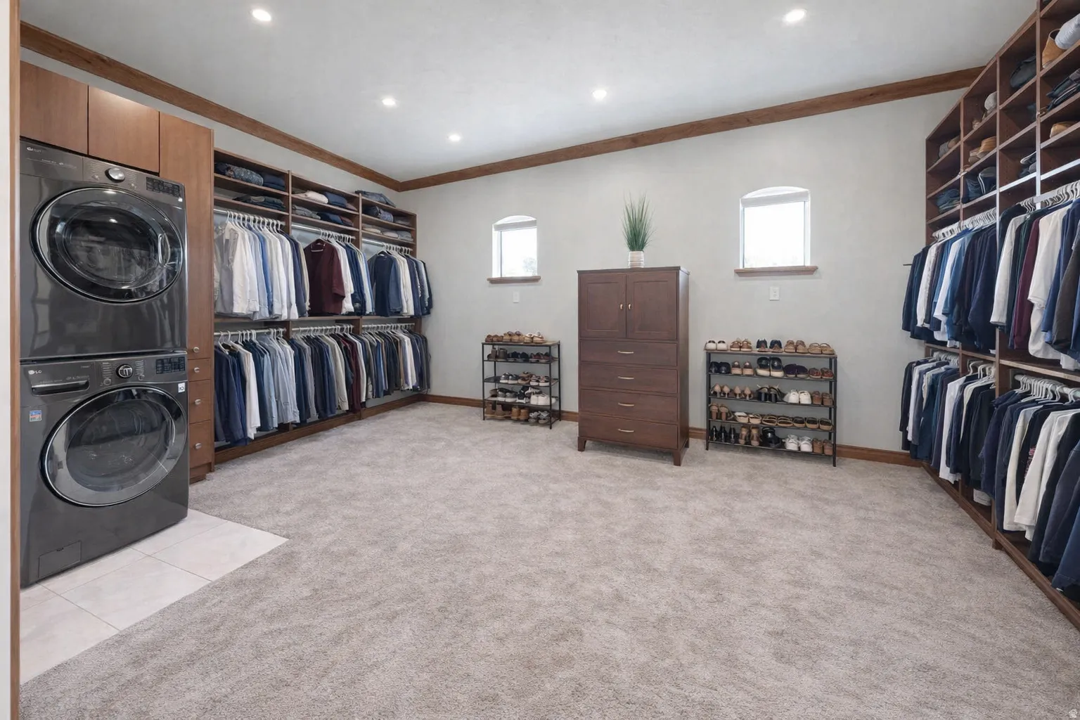 Walk in closet with light carpet and stacked washer and clothes dryer