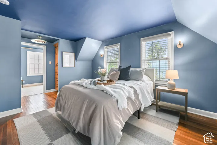 Bedroom with wood-type flooring and lofted ceiling