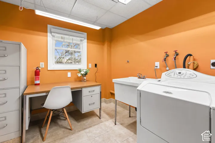Laundry room featuring washer / dryer, a paneled ceiling, and an office area