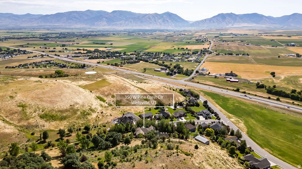 Expansive rural setting featuring a distant mountain range, agricultural fields, and a residential area