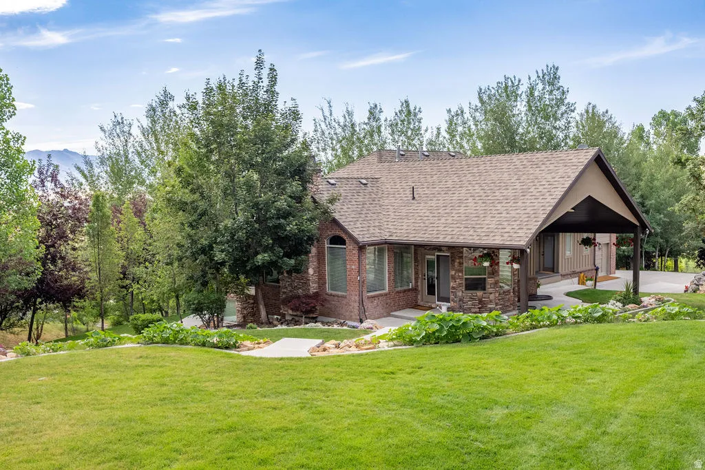 Expansive green lawn sloping towards a brick and stone residence