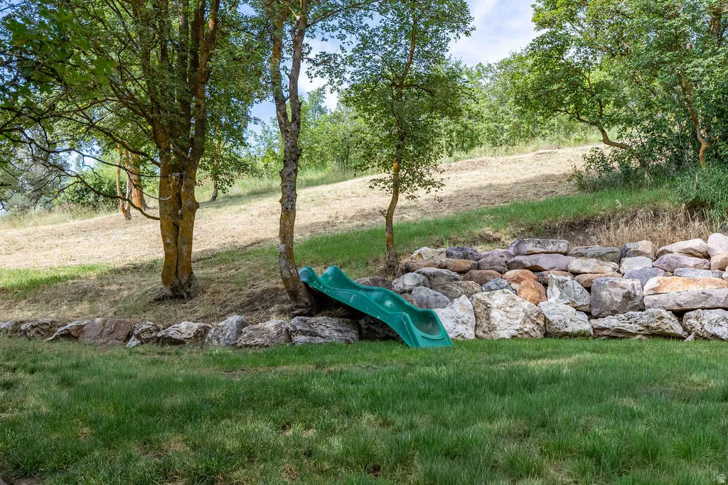 Tiered landscaping featuring a rock retaining wall and sloped natural terrain
