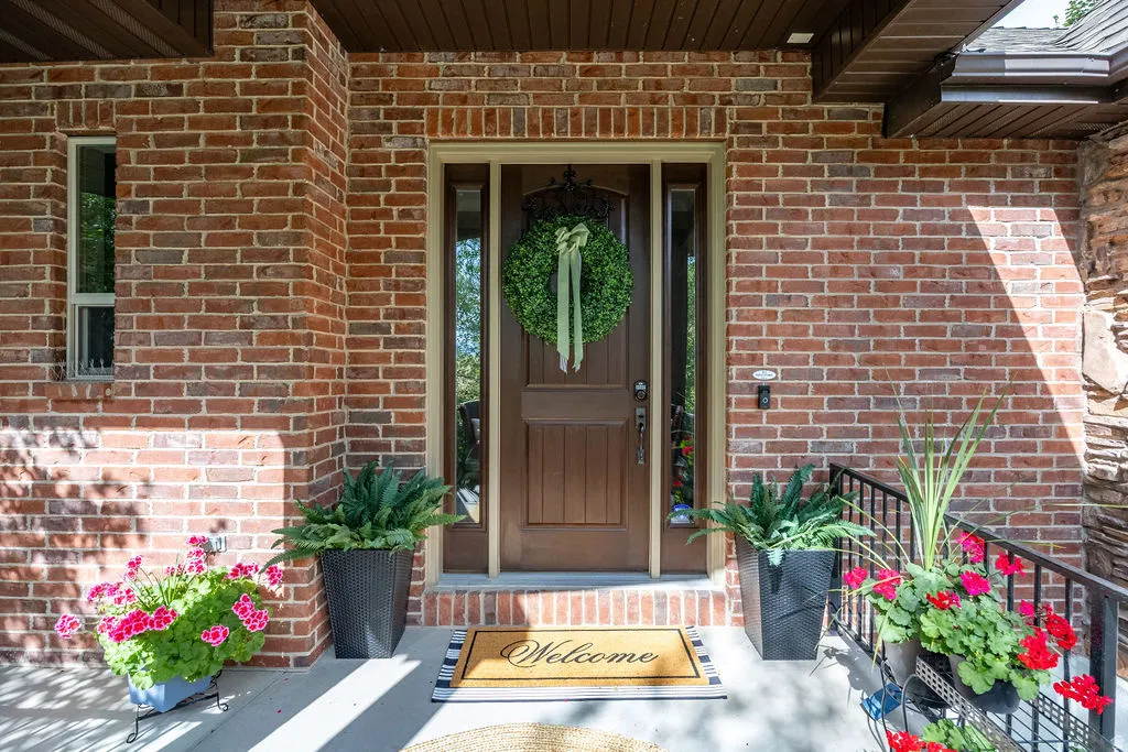 Brick exterior featuring a wood-paneled entry door with sidelights and a transom