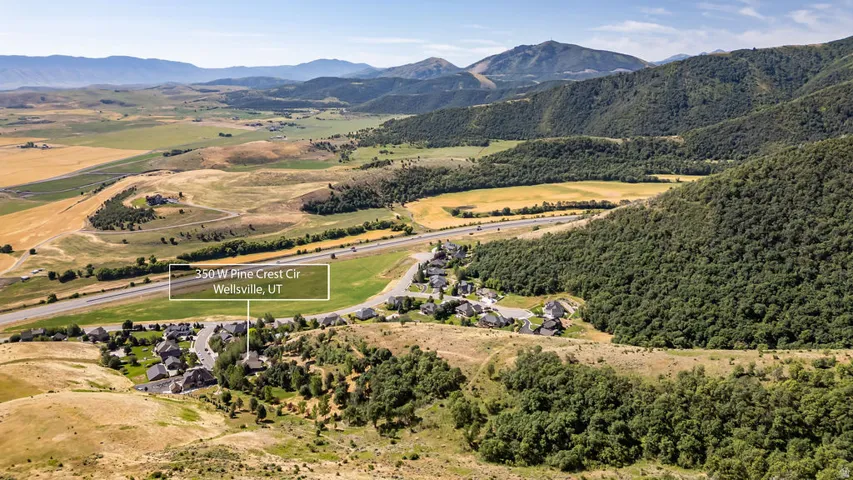Aerial perspective showcasing a residential community nestled among rolling hills and extensive green spaces