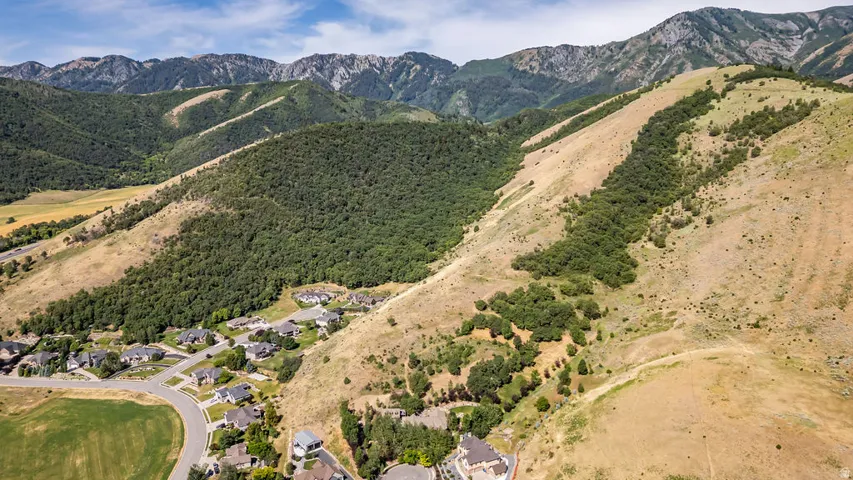 Expansive mountain landscape featuring rugged peaks and verdant foothills