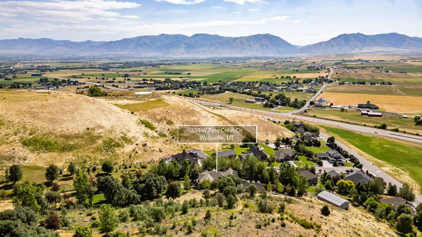 Expansive aerial perspective showcasing a residential neighborhood nestled against a mountainous backdrop