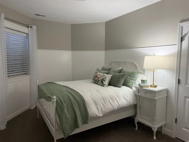 Bedroom with wainscoting and dark carpet