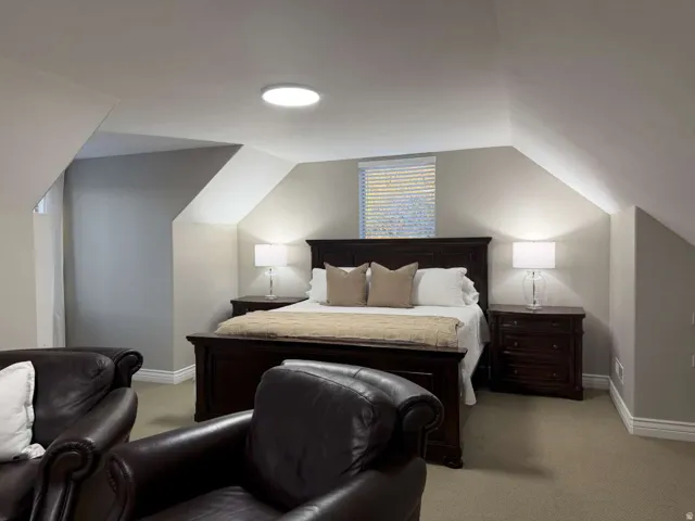 Bedroom featuring light colored carpet and lofted ceiling