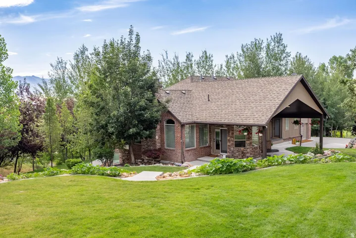 Expansive green lawn sloping towards a brick and stone residence