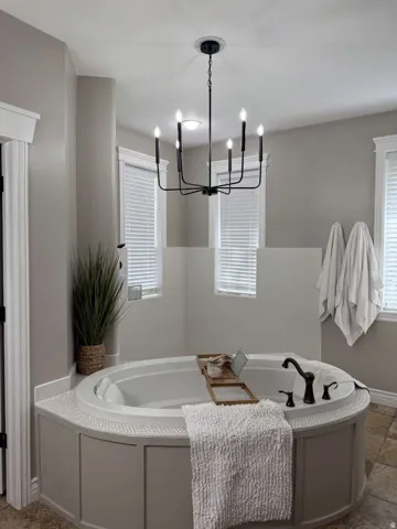 Full bath featuring a bath, plenty of natural light, and suspended lighting