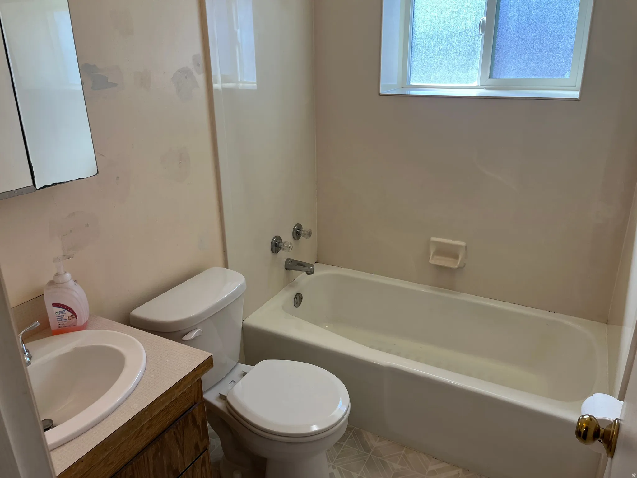 Bathroom with vanity, healthy amount of natural light, and  shower combination
