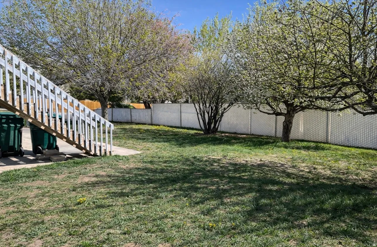 Fenced backyard with stairs and a patio area