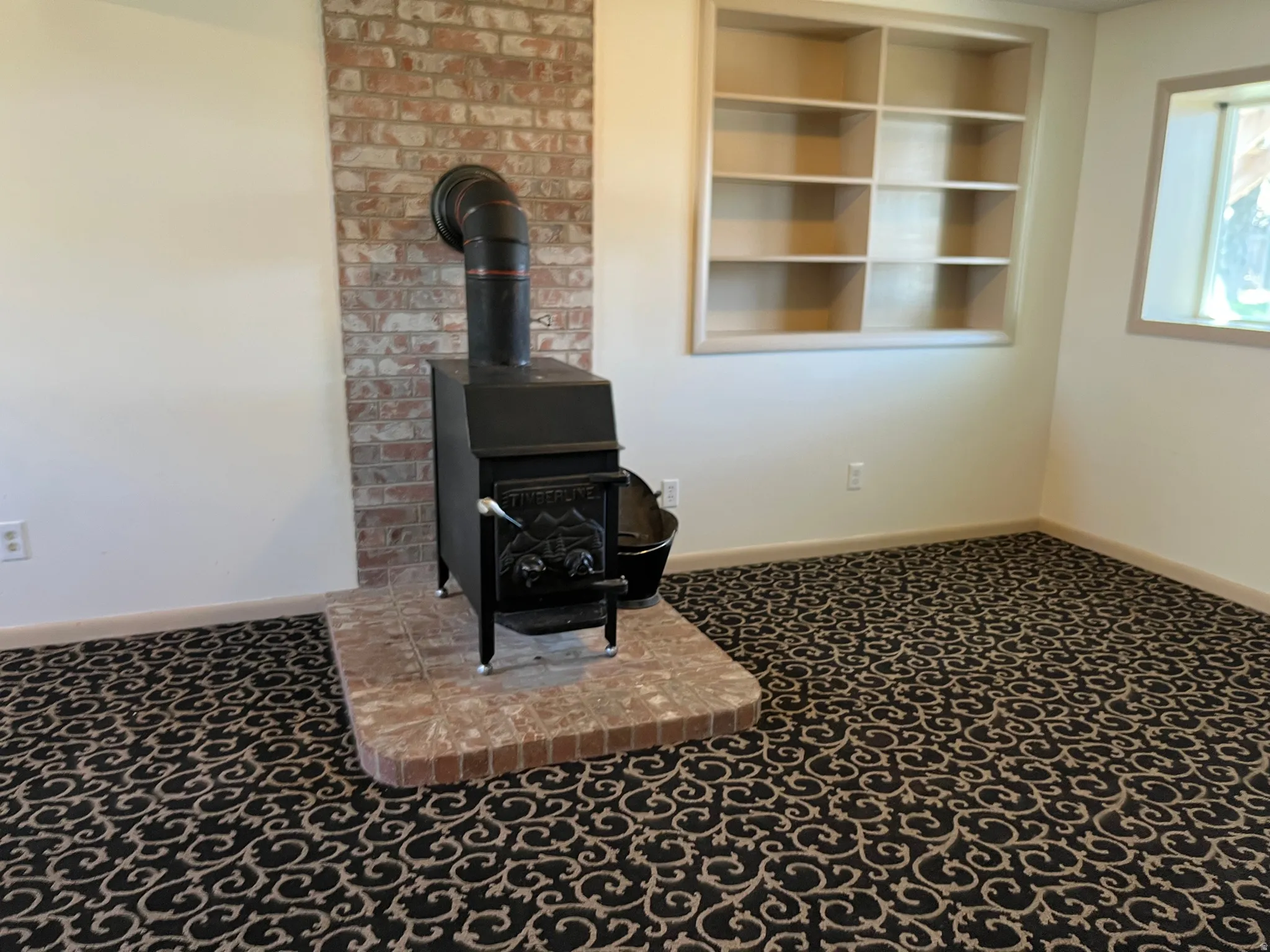 Detailed view of carpet, a wood stove, and built in features