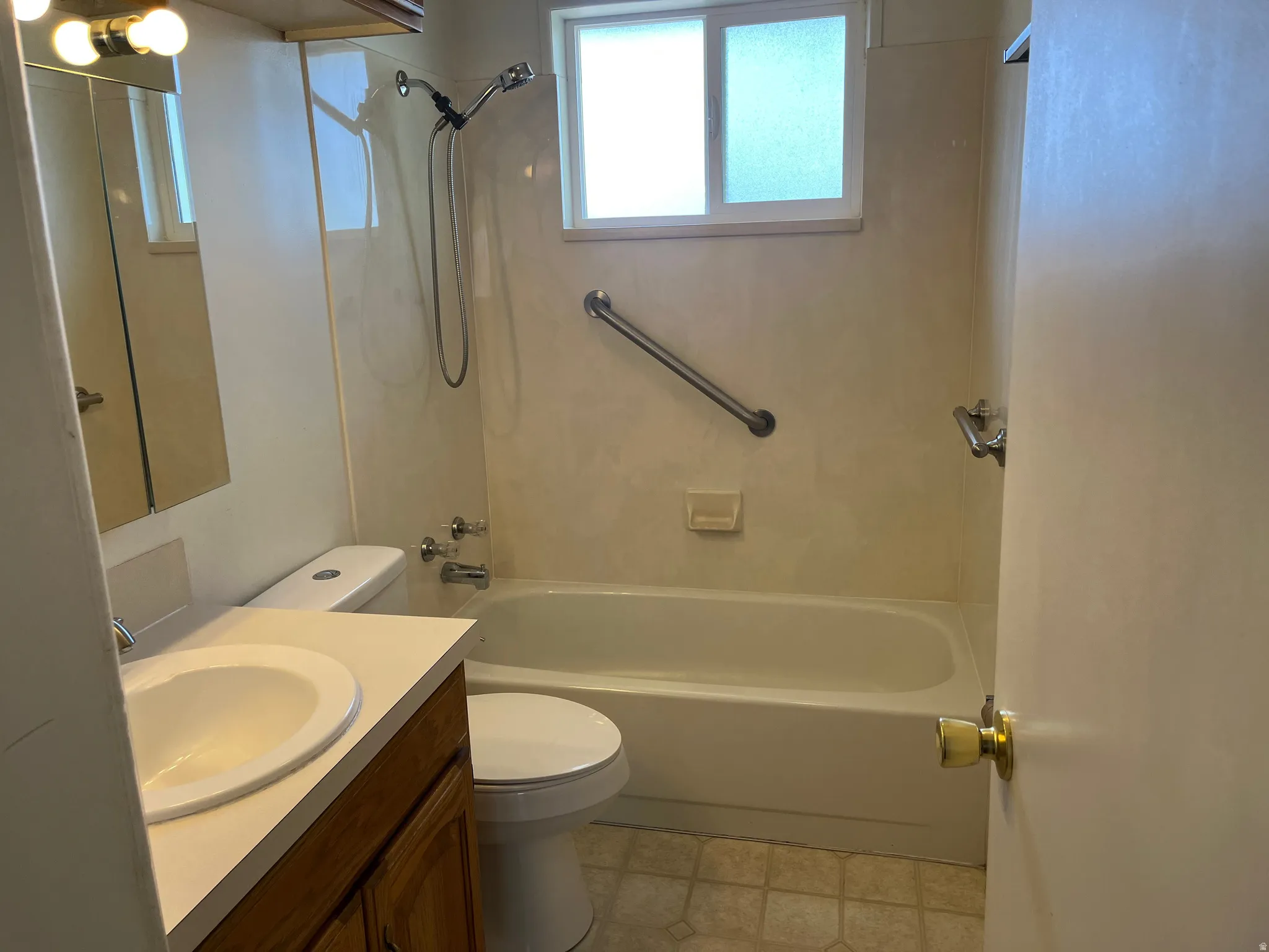 Bathroom with vanity, bathing tub / shower combination, and light flooring
