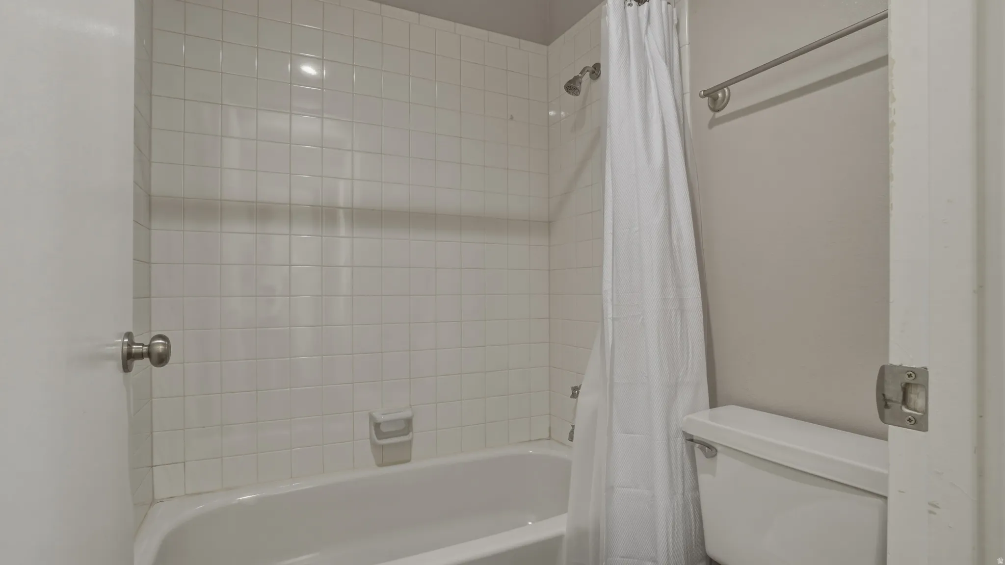 Bathroom with toilet and shower / bath combo with shower curtain