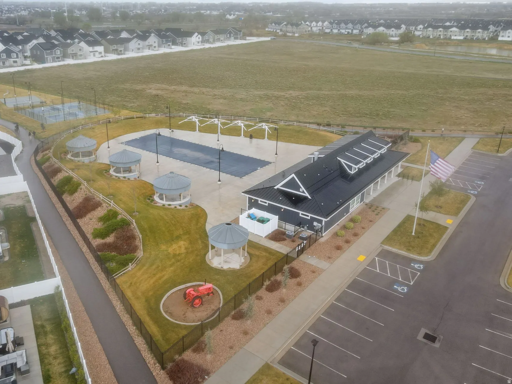 Aerial view of community amenities including pool, clubhouse, pickleball courts, picnic area.