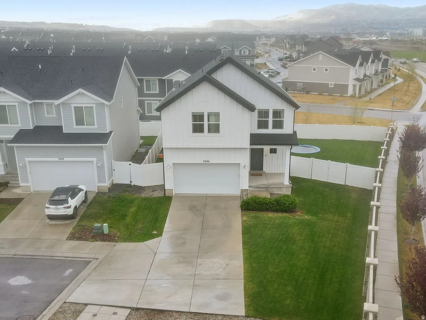 Aerial view showing large fenced yard and large driveway