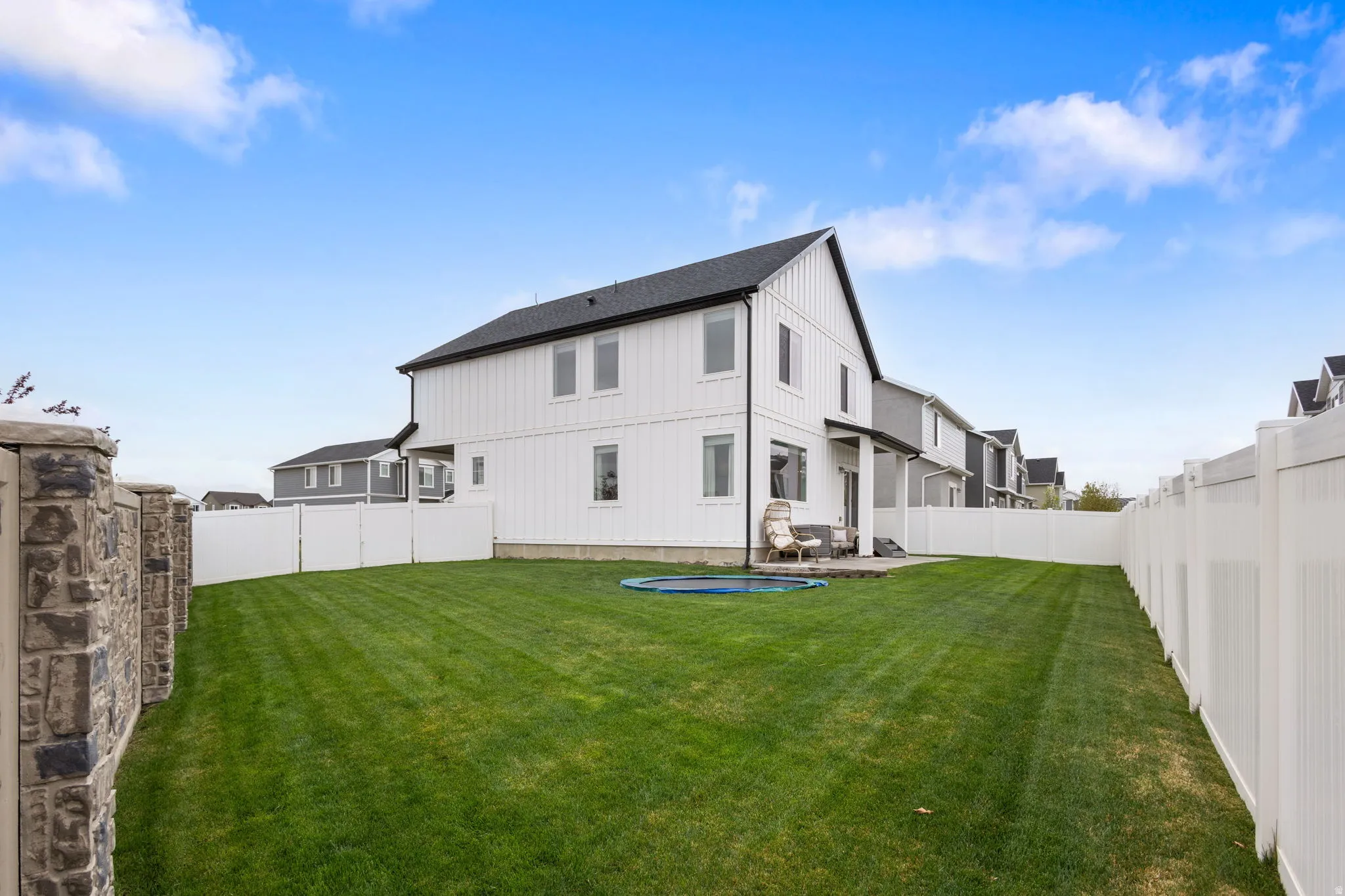 Rear view of house featuring a patio area, a fenced backyard, and Hardie Board siding