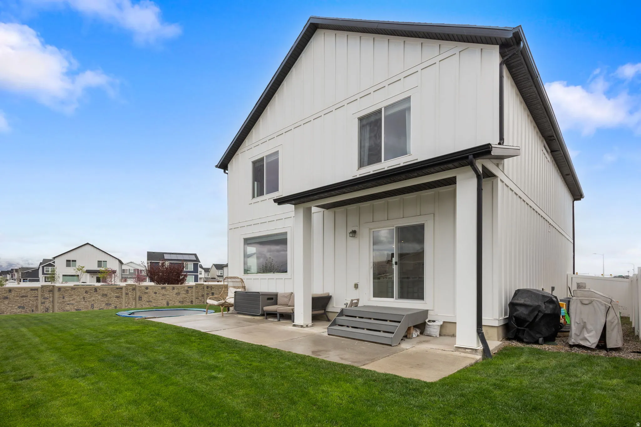 Rear view of property with Hardie Board siding and patio area