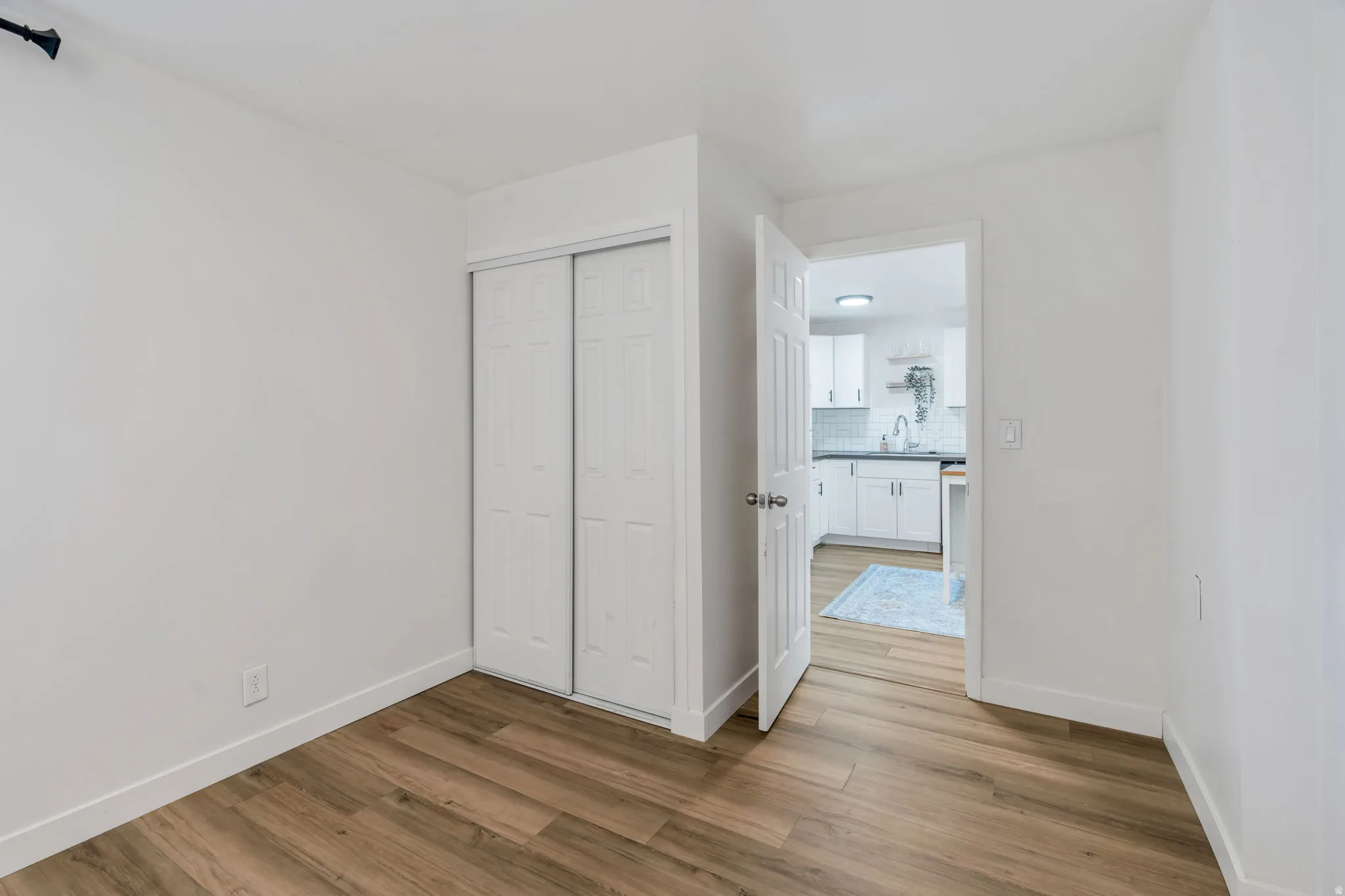 Unfurnished bedroom with light wood-style flooring and a closet
