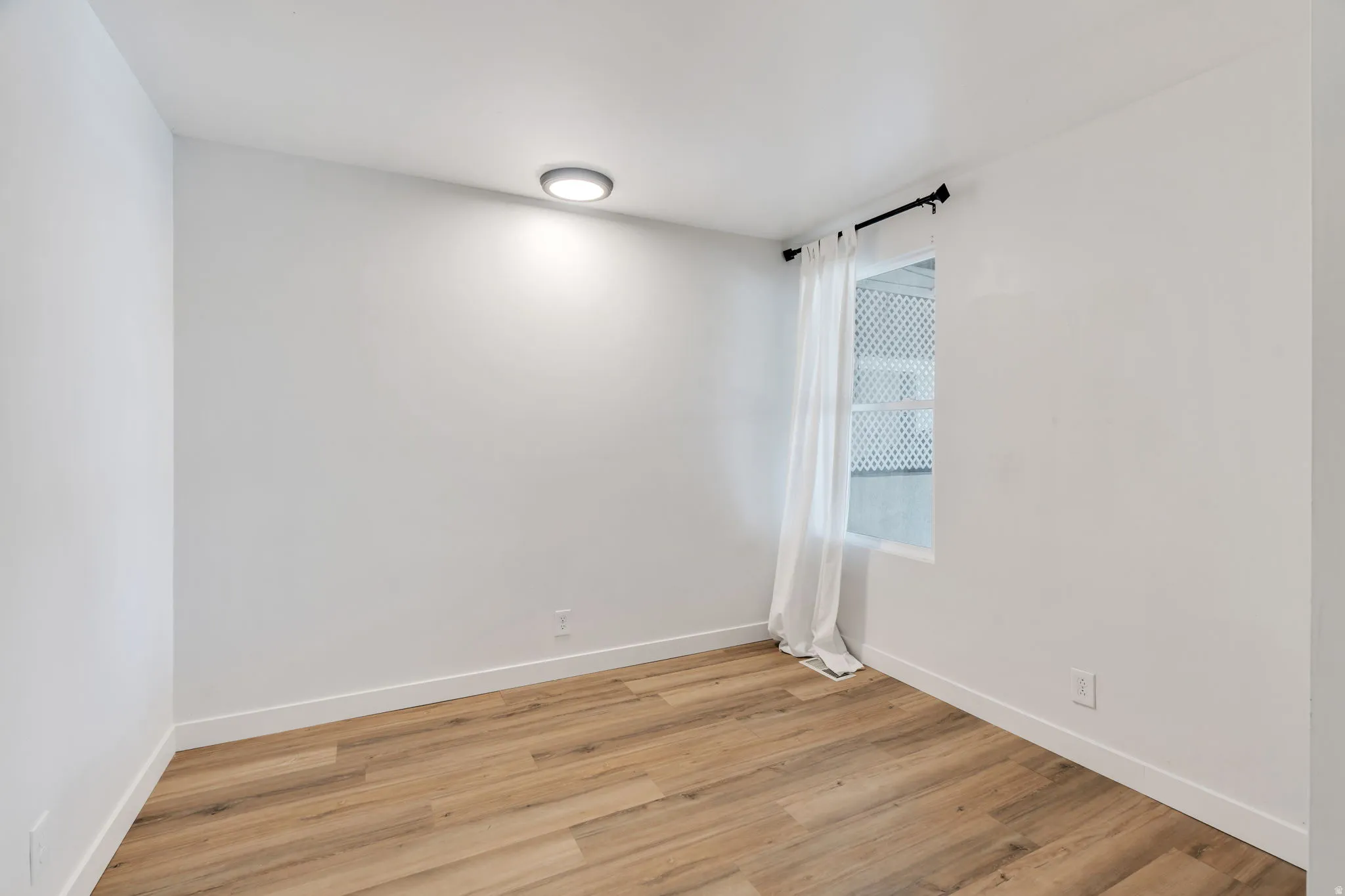 Empty room featuring light wood-style flooring and baseboards