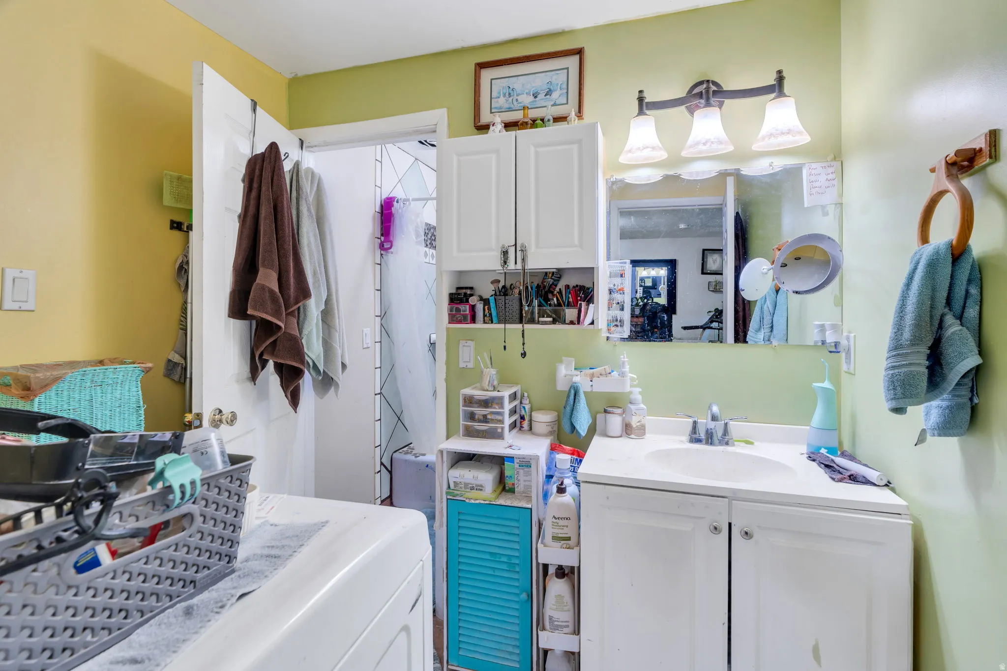 Bathroom featuring vanity and washer / dryer