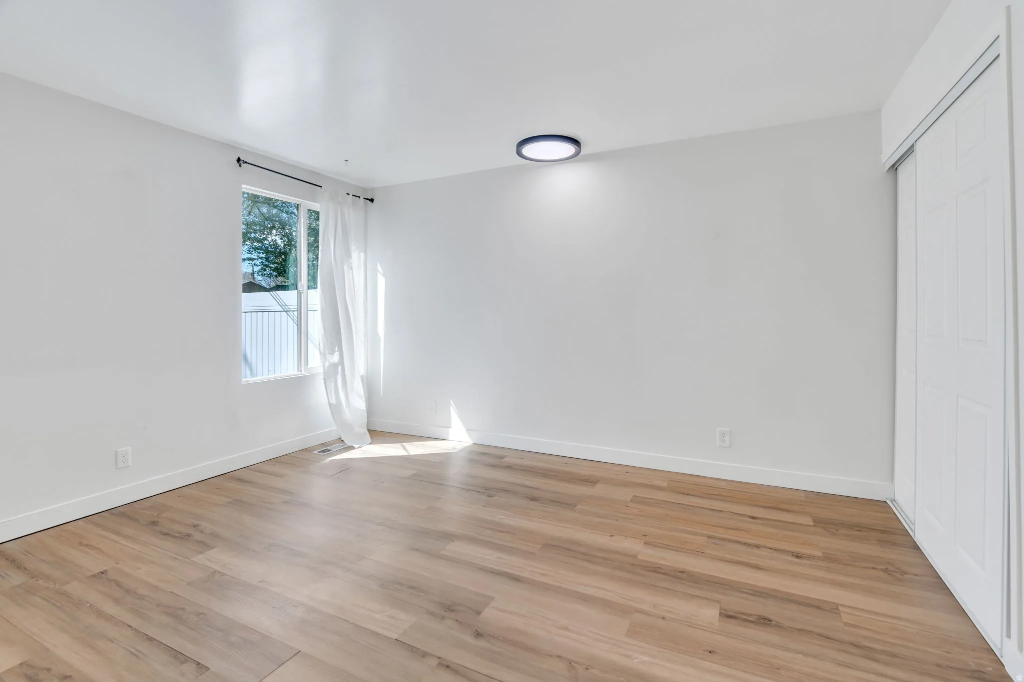 Unfurnished bedroom featuring light wood finished floors and a closet