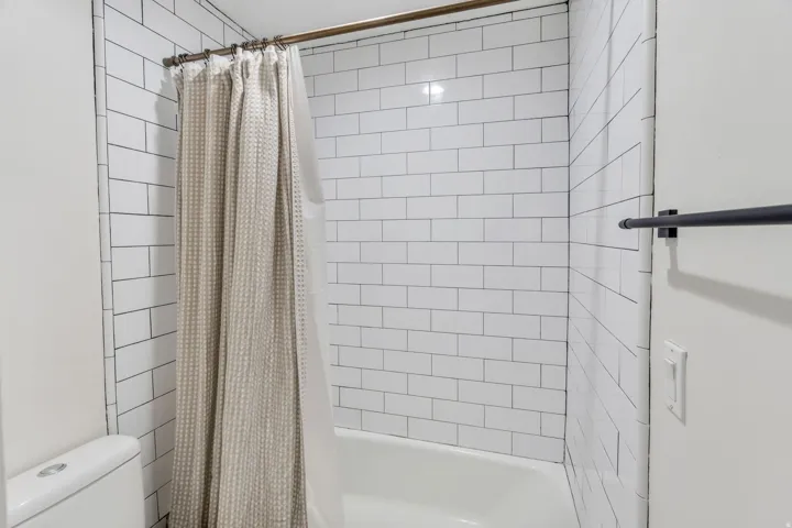Full bathroom featuring shower / tub combo and toilet