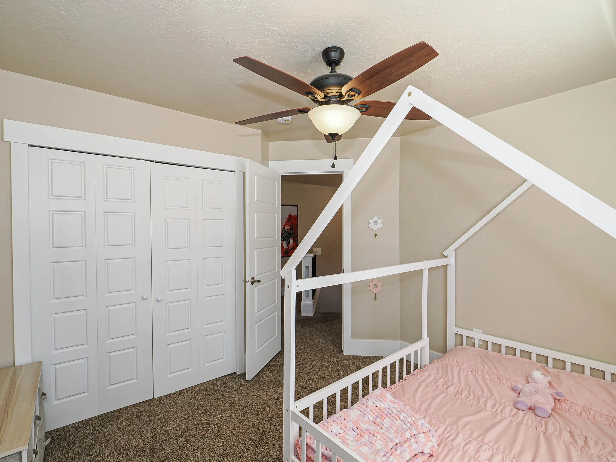 Bedroom with dark carpet, a closet, ceiling fan, and a textured ceiling