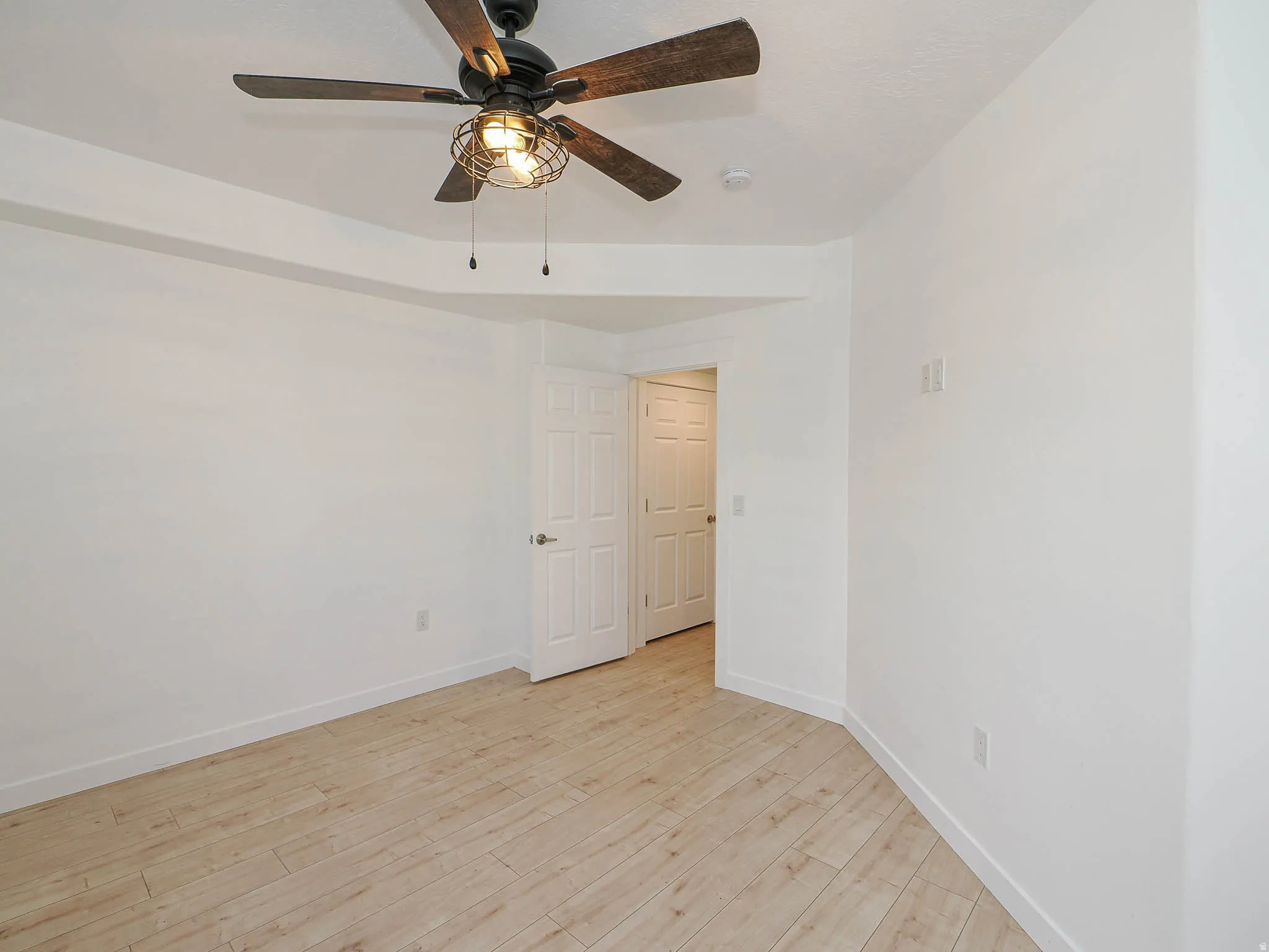 Unfurnished room with light wood finished floors and a ceiling fan