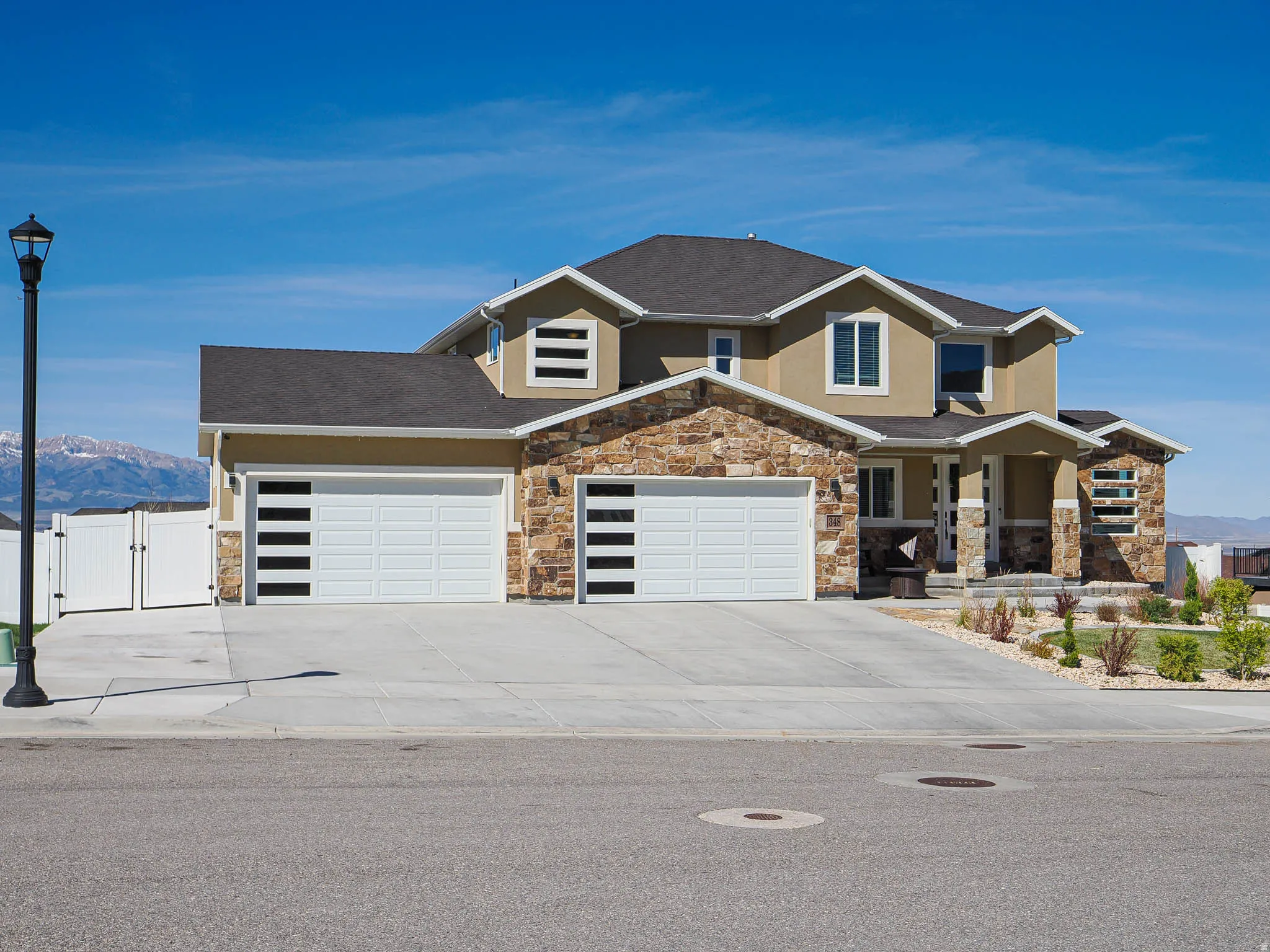 View of front facade featuring a gate, a mountain view, stucco siding, stone siding, and covered porch
